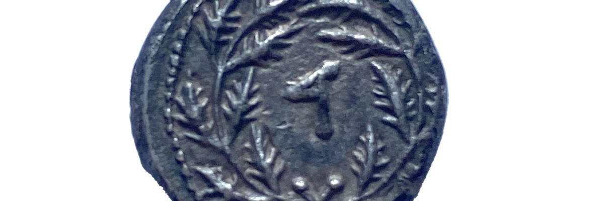 זר צמחי ובמרכזו האות ד. המציינת את השנה הרביעית למרד, בה נטבע המטבע. צילום-באדיבות רשות העתיקות